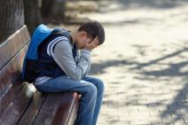 Dečak plače na klupi napolju