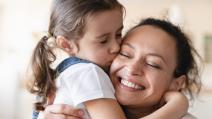 Ćerka grli i ljubi mamu