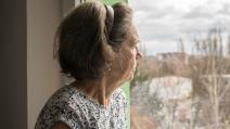 Usamljena baka gleda kroz prozor