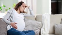 Trudnica sedi s rukom na stomaku