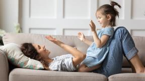 Mama se zabavlja sa ćerkom na kauču