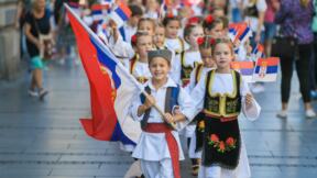 Deca u narodnoj nošnji sa srpskom zastavom