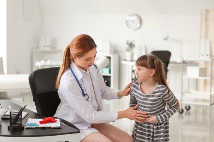 Lekar pregleda devojčicu sa bolom u stomaku