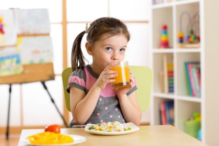 Devojčica pije sok uz doručak