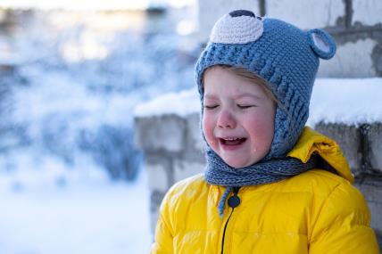Dete ne želi da nosi zimsku kapu.