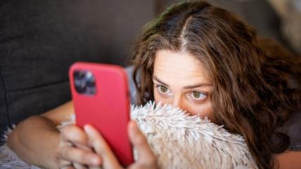 Žena iznenađeno gleda u telefon