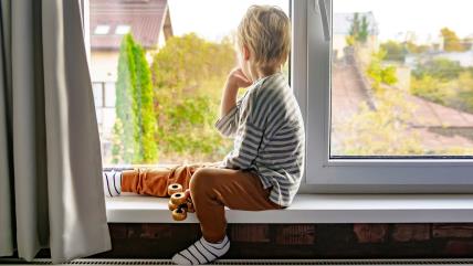 Dečak gleda kroz prozor