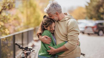 Otac grli i ljubi ćerku u glavu
