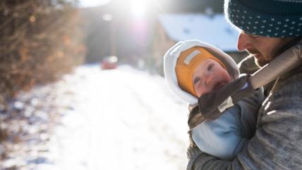 Tata drži bebu u nosiljci