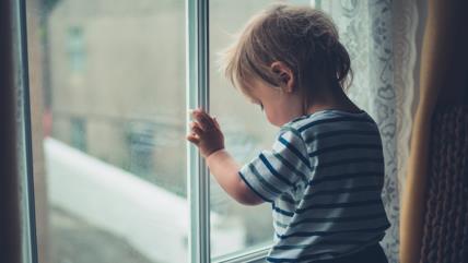Dete stoji pored prozora