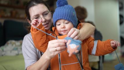 Mama oblači detetu rukavice