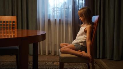 Devojčica sedi na stolici