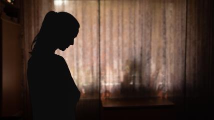 Tužna žena stoji pored prozora
