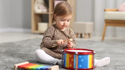 Mala devojčica sa dečjim muzičkim instrumentima