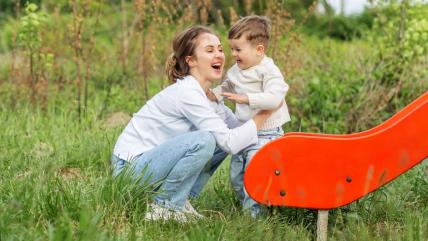 Majka sa detetom ispred tobogana