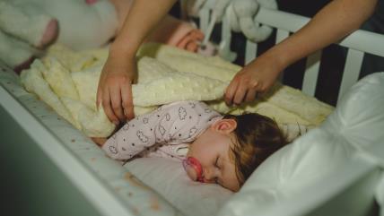Mama pokriva bebu koja spava
