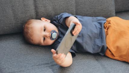 Beba drži telefon u rukama