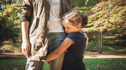 Devojčica se krije iza mame