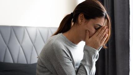 Žena s rukama na licu plače