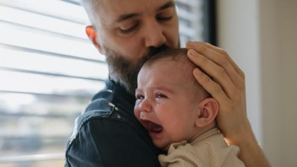 Tata drži uplakanu bebu