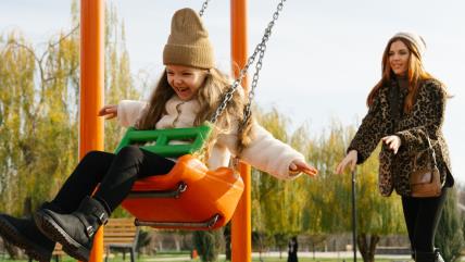 Mama ljulja ćerku u parku