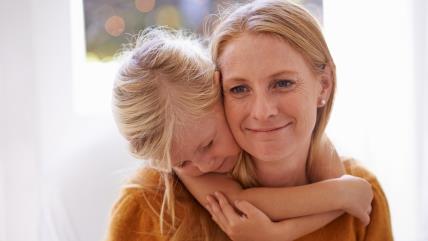 Devojčica grli majku s leđa