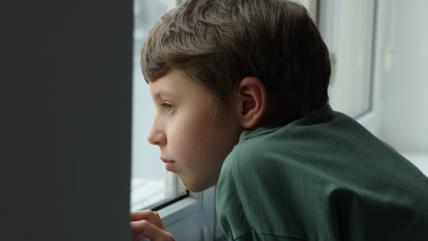 Dečak gleda kroz prozor