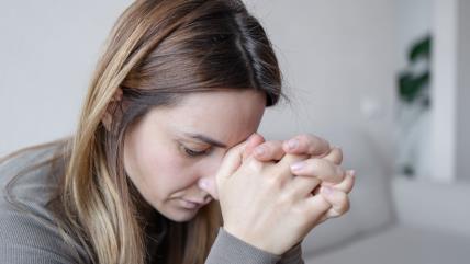 Zabrinuta žena glave naslonjene na ruke