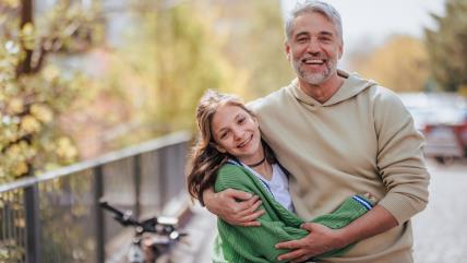Tata zagrljen sa ćerkom napolju