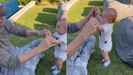 Enrike Iglesijas drži bebu za ruke da stoji