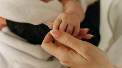 Beba drži mamu za prst