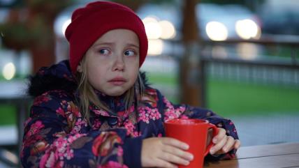 Devojčica plače sa šoljom u ruci