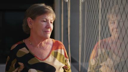 Zamišljena starija žena pored prozora