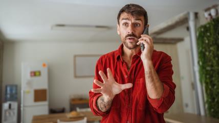 Zabrinuti muškarac priča na telefon kod kuće