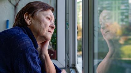 Tužna baka gleda kroz prozor