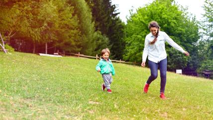Mama i dete trče po travi