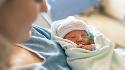 Mama drži novorođenu bebu