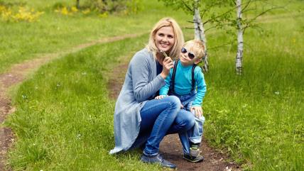 Mama sa detetom drži cvetiće u ruci