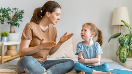 Mama grdi uplakanu devojčicu na krevetu