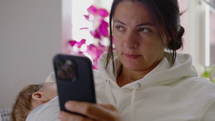 Žena čita poruke na telefonu i razmišlja