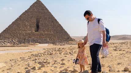Tata sa ćerkom pored piramide u Egiptu