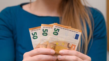 Žena drži novac u rukama