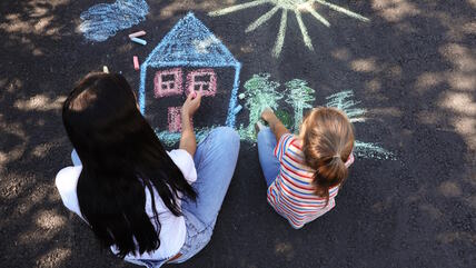 Devojčica i mama crtaju kredama na betonu