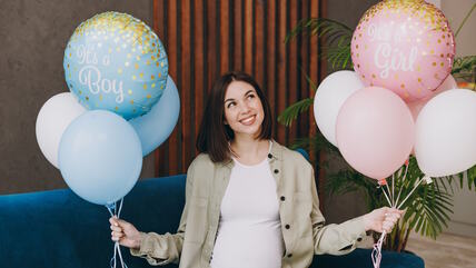 Trudnica sa plavim i roze balonima
