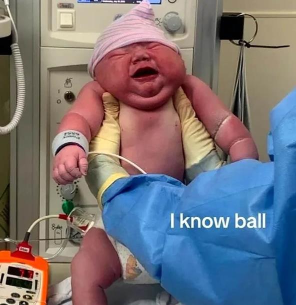 Lekar drži u rukama veliku bebu