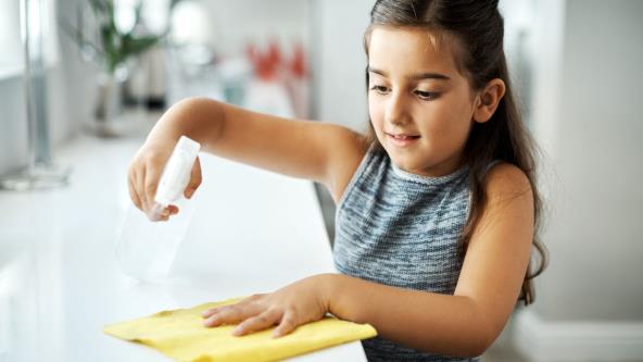 Devojčica briše prašinu sa stola