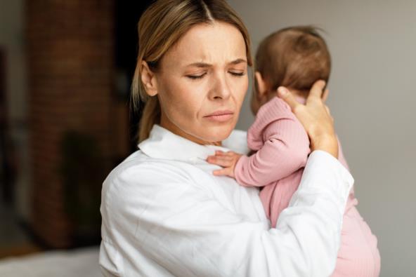 Umorna mama drži bebu