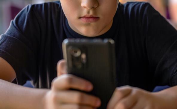 Dečak drži mobilni telefon