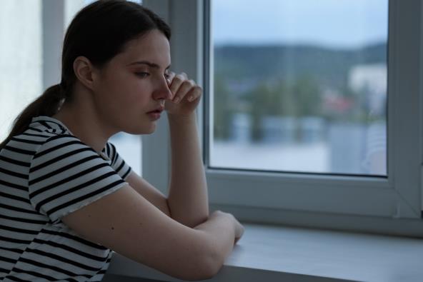 Tužna žena pored prozora
