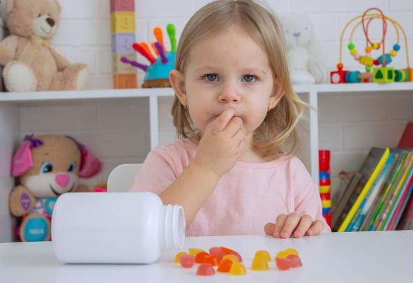 Devojčica jede gumene vitamine